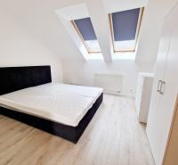 A bright room with a bed and built-in wardrobes in a three-room apartment.