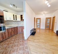 A kitchen in a 3-room apartment with built-in appliances and a wooden decor floor.