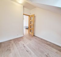 A room in a 3-room apartment with a wooden decor floor and light walls.