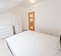 Bedroom with a bed, wardrobe, and wooden decor flooring in a 3-room apartment.