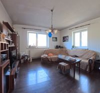 Living room in a family house with a dark floor and a sofa set.
