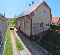 A family house in Svinná with a car on the driveway and a well-maintained garden.