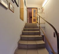 A staircase with a wooden railing in a family house, decorated with pictures.