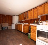 A kitchen in a family house with wooden cabinets and a floor with a wooden decor.
