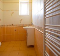 A bathroom in a family house with yellow walls and a white radiator.