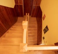 Staircase with wood decor flooring in a family house, walls paneled with wood.