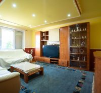 Living room in a family house with wooden furniture and a glass cabinet.
