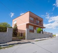 A family house on B. Tablica Street in Dudince with a stone fence and blue sky.