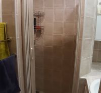 A shower corner in the bathroom with tiles in a 2-room apartment.
