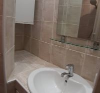 A small bathroom with a sink and a mirror in a 2-room apartment.