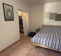 Bedroom with ceramic tiles, wall drawing, and bed in a family house.
