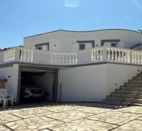 A family house in Vinjerac with a white facade, stone paving, and railing.