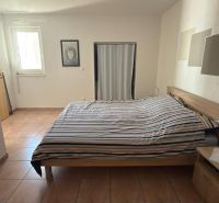 A bedroom in a family house with a bed, ceramic flooring, and minimalist decor.