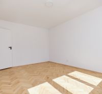 An empty room in a 3-room apartment with a wooden decor floor.
