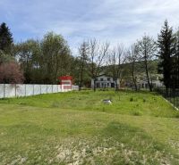 A garden with a lawn on a property in Borinka, surrounded by trees and a white fence. Plots - residential.