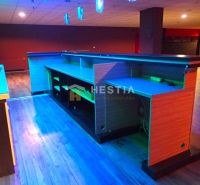 Night bar with a lit counter, wooden floor, and space for commercial premises.