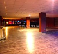 Spacious commercial spaces with wooden flooring and columns, suitable for various purposes.