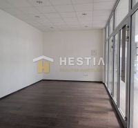 A spacious room with glass doors and a dark floor in a 2-room apartment.