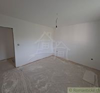 A room in a family house with white walls and a wooden decor floor.