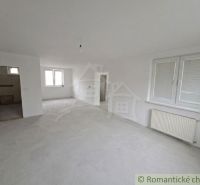 Spacious room in a family house with white walls and large windows.