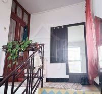 A staircase in a family house with colorful tiles and a curtain.