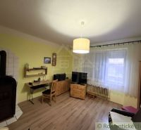 Living room with tiles, wooden furniture, and a floor with a wood design.