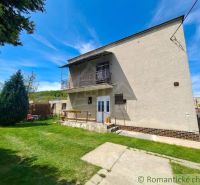 A family house in Mýtna with a garden and a balcony under the blue sky.