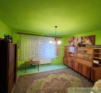 A room in a family house with striking green walls, furniture, and carpet.