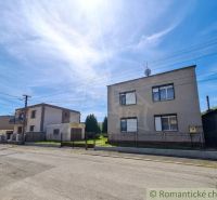 Family houses in Mýtna near a street with a clear sky and a fence.