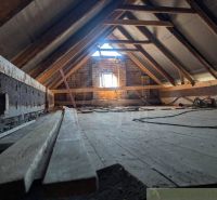 An attic with exposed beams and a wooden decor floor in a family house.