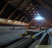 The attic of a family house with wooden beams and stored wood.