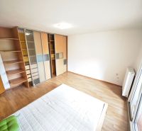 Bright bedroom in a 3-room apartment with wood-patterned flooring and a built-in wardrobe.