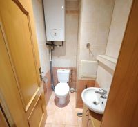 Bathroom in a 3-room apartment with a shower, sink, and boiler, tiles in soft shades.