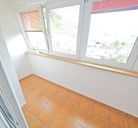 A bright loggia with glass and terracotta tiles in a 3-room apartment.
