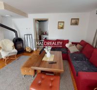 Living room in a family house with a fireplace, a comfortable sofa, and a wooden table.