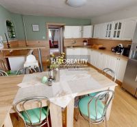 A kitchen in a family house with white cabinets and a wooden decor floor.