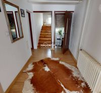 Interior of a family house with a wooden decor floor and a staircase with a railing.