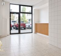 A bright room with large windows and tiled flooring, ideal for commercial spaces.