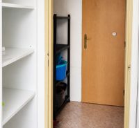 In the commercial premises, there are white shelves, doors, and a cleaning rack.