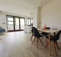 A bright interior of a 3-room apartment with white walls and a floor with a wood decor.