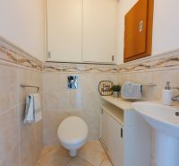 Bathroom in a 3-room apartment with a toilet, sink, and cabinet.