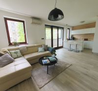 Living room with a kitchenette, sofa, and wooden decor flooring in a 3-room apartment.