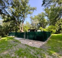 A cottage in Gabčíkovo surrounded by greenery by the river with a fenced plot.