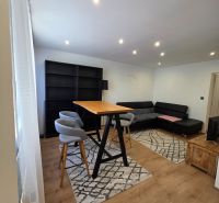 Living space in a 3-room apartment with wood-patterned flooring and furniture.