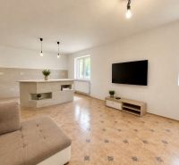 Living room in a family house with a TV, sofa, and tiles.