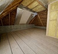 The attic of a family house with a wooden decor floor and insulation.