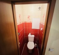 A bathroom with red tiles in a 3-room apartment.