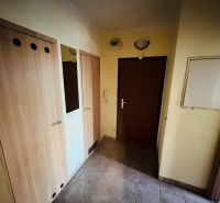 A hallway in a 3-room apartment with tiles and wooden doors.