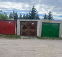 Garages on Gúgska Street in Nové Zámky with colorful doors and surrounding vegetation.