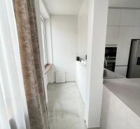 A kitchen in a 3-room apartment with white cabinets and a marble floor.